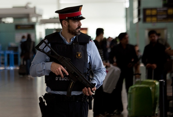 Полицейский охраняет терминал аэропорта в Барселоне (Испания), где введены усиленные меры безопасности на фоне терактов в Брюсселе 22 марта.